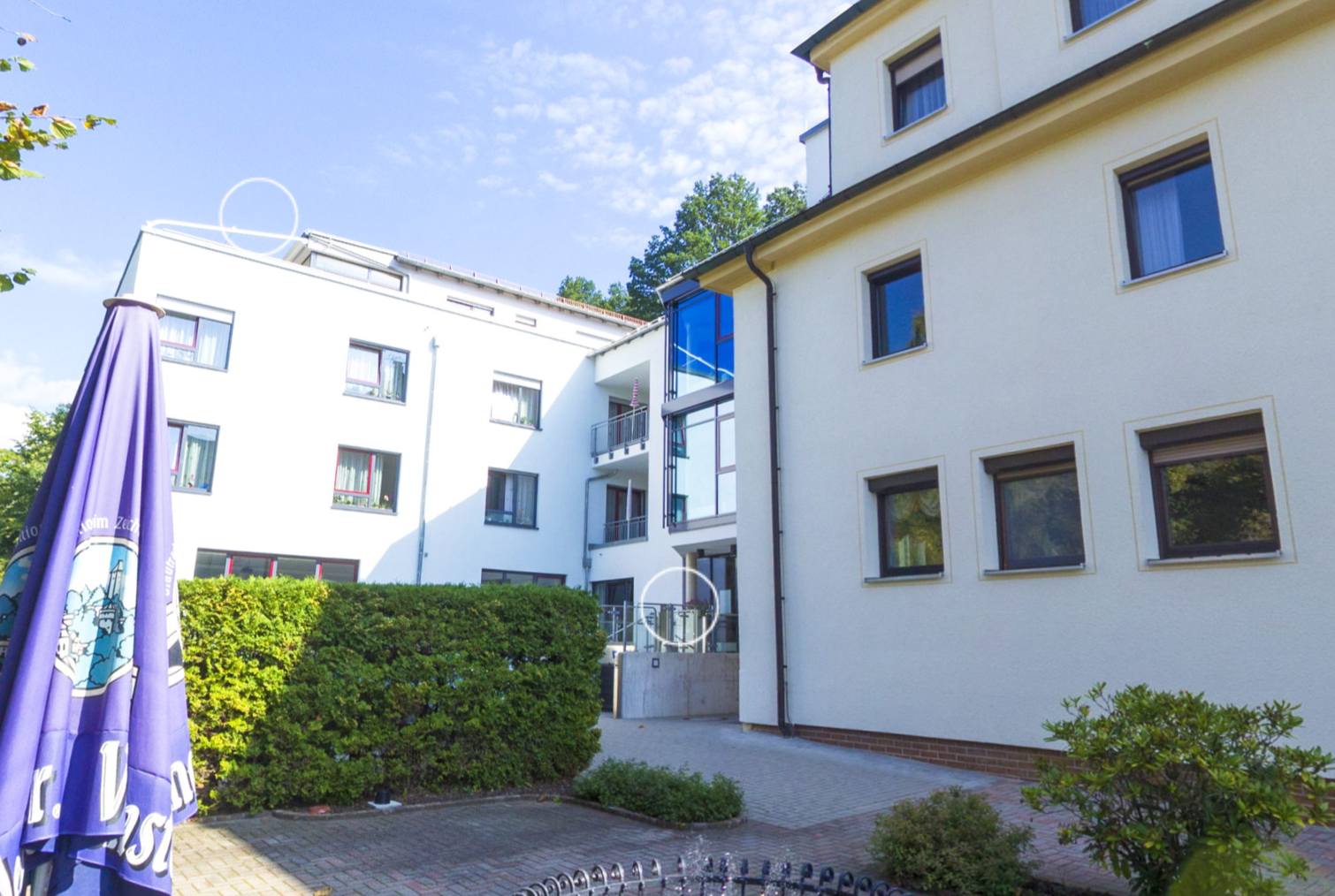 Sonniger Innenhof des Hauses mit Brunnen und gepflegtem Garten